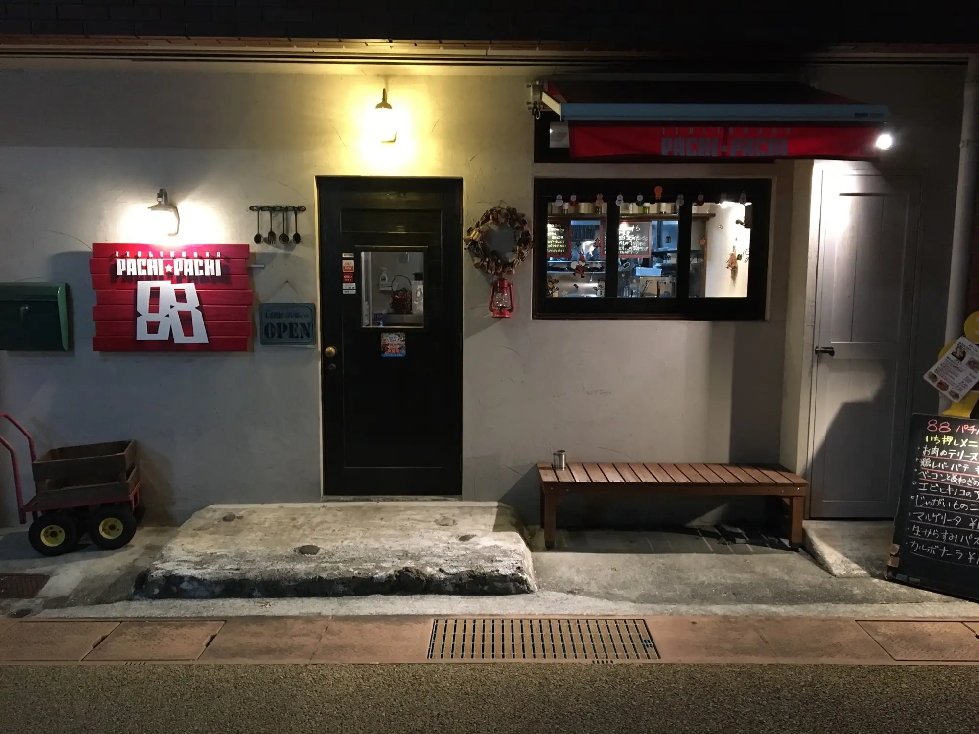 パチパチ外観。夜の店の入口と赤い看板