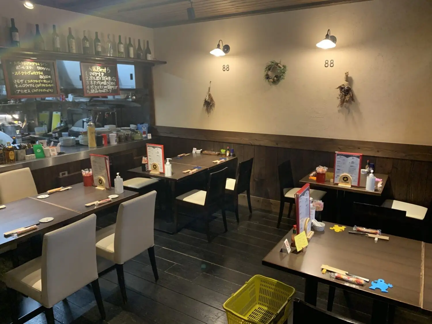 落ち着いた照明の店内。木の腰壁とテーブル席